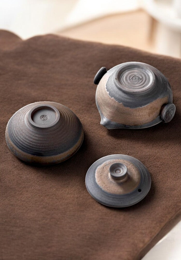 Underside of teapot and tea bowl showing glaze details and base rings