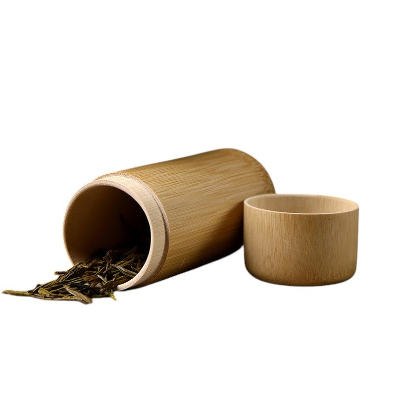 Open bamboo tea jar with loose leaf spilling, eco tea storage