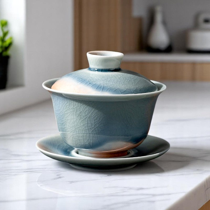 Gaiwan set on wooden tray, glowing glaze with blue-orange contrast