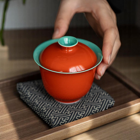 Color contrast gaiwan on bamboo tray, red exterior and green inner glaze