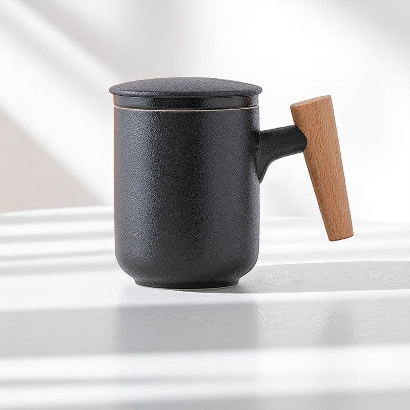 Black ceramic tea cup with wood handle and lid on white table