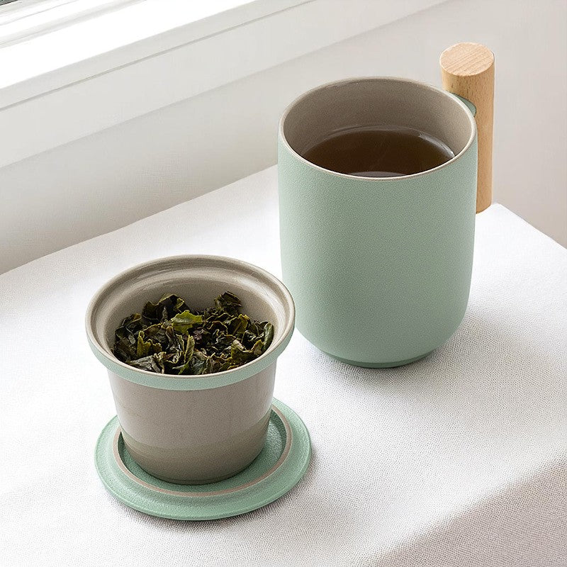 Sage green ceramic tea mug with infuser brewing loose leaf tea