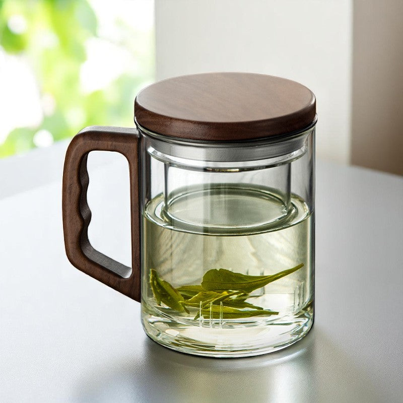 Glass tea mug with walnut handle and visible green tea brewing