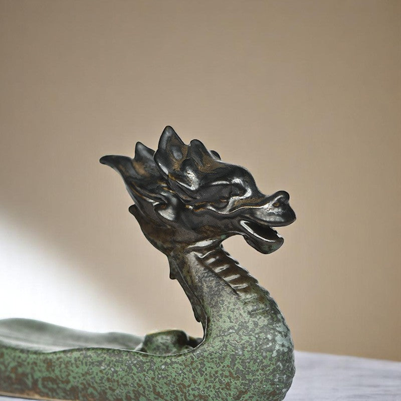 dragon-shaped incense holder in green ceramic, with focus on the dragon head.