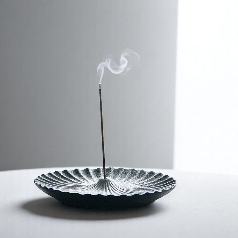 Zen ceramic incense plate with incense smoke rising, japandi interior