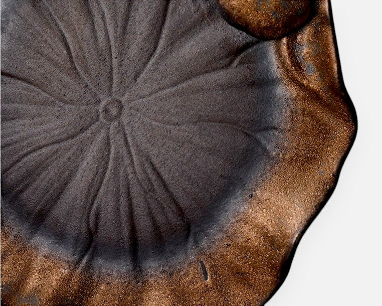 Lotus-shaped saucer with natural glaze variation and unglazed clay texture