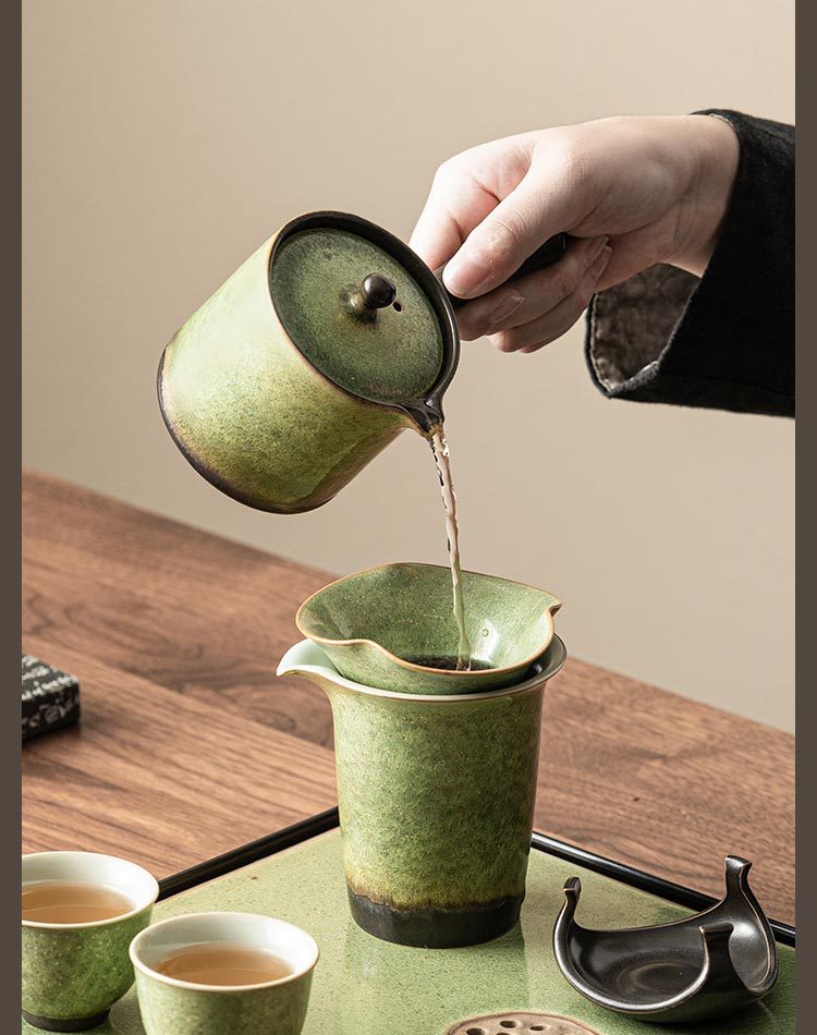 Pouring water into green ceramic teapot, minimalist tea setup
