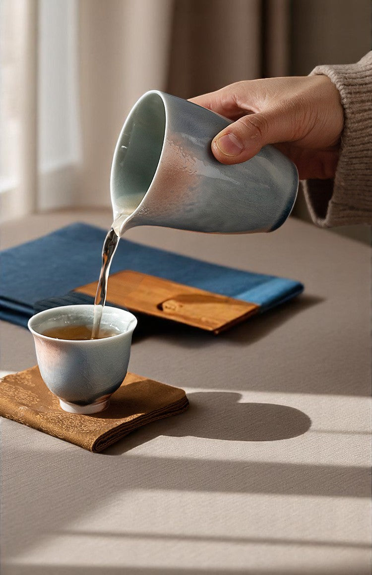 Pouring tea into small crackled glaze cup, natural lighting on texture