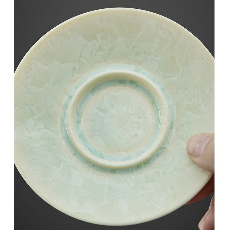 Close-up of icy glaze pattern on jade-colored ceramic saucer