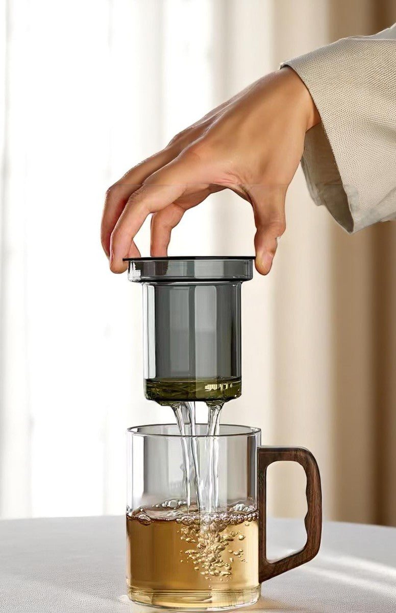 Lifting infuser from glass mug, tea stays in cup for clean brewing