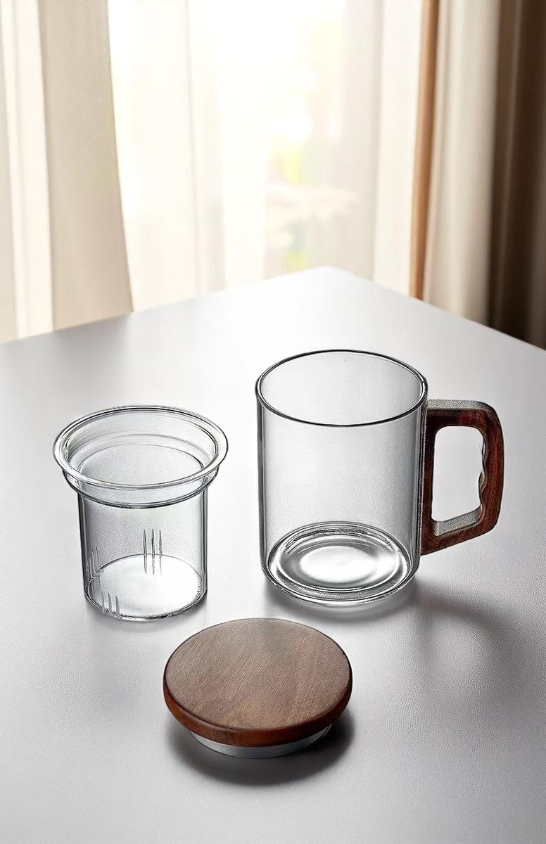 Clear glass tea mug set with infuser and wooden lid shown separately