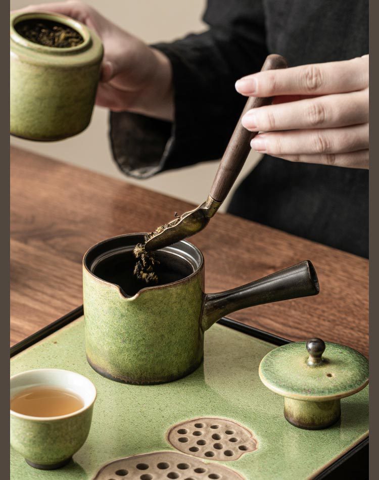 Pouring water into green ceramic teapot, minimalist tea setup