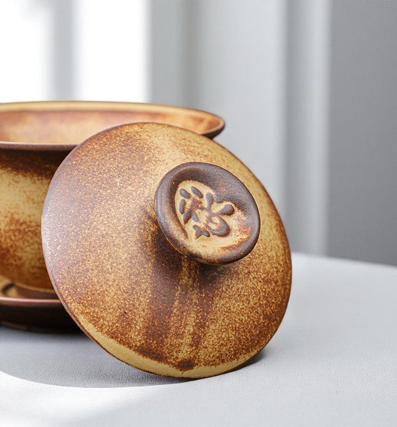 Brown glazed gaiwan with lid on a light gray surface
