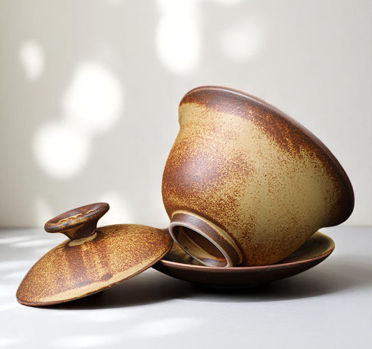 Ceramic Gaiwan with brown speckled glaze on a light background